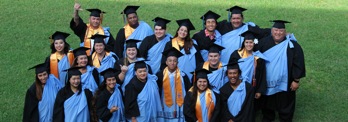 group of happy grads at commencement with college kihei and several wearing PTK stoles