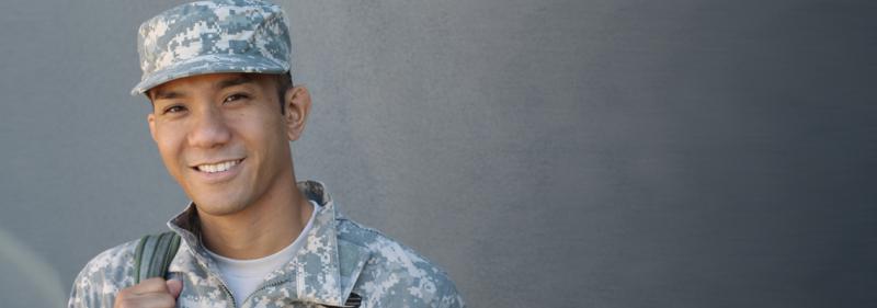 male army solder in camo uniform against gray background
