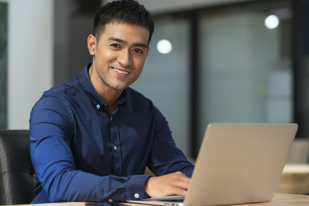 Business man sitting at desk with laptop