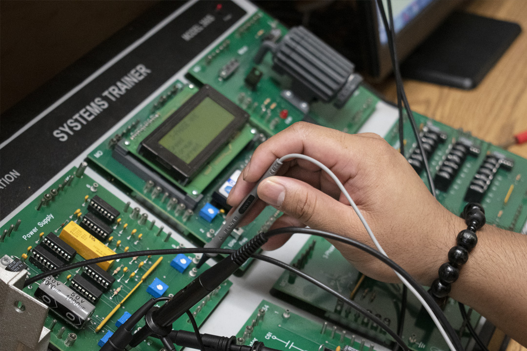 Closeup of a hand working on electronic training machine